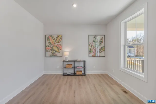 a view of a bedroom with wooden floor and window
