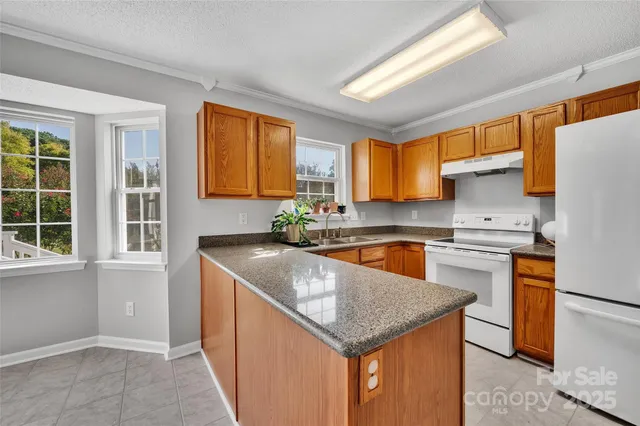 a kitchen with stainless steel appliances granite countertop sink stove and refrigerator