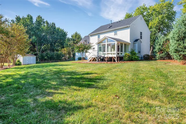 an aerial view of residential houses with outdoor space and trees
