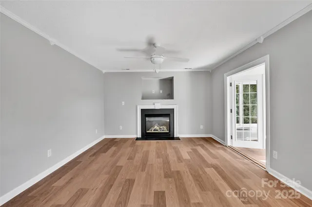 a view of an empty room with a window and fireplace