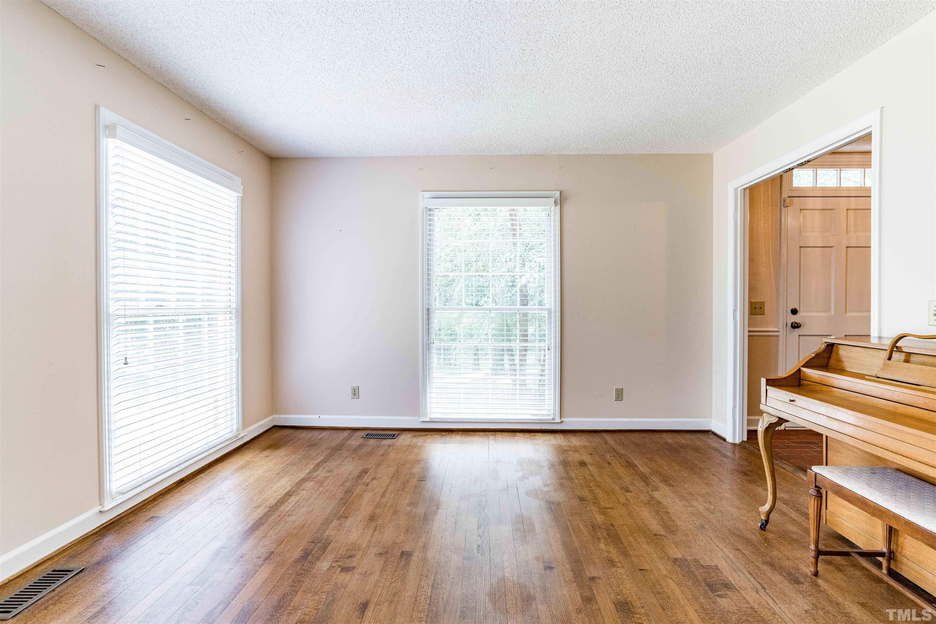 8424 Crowder Road Raleigh, NC 27603 - Photo 13 of 70 an empty room with wooden floor and windows
