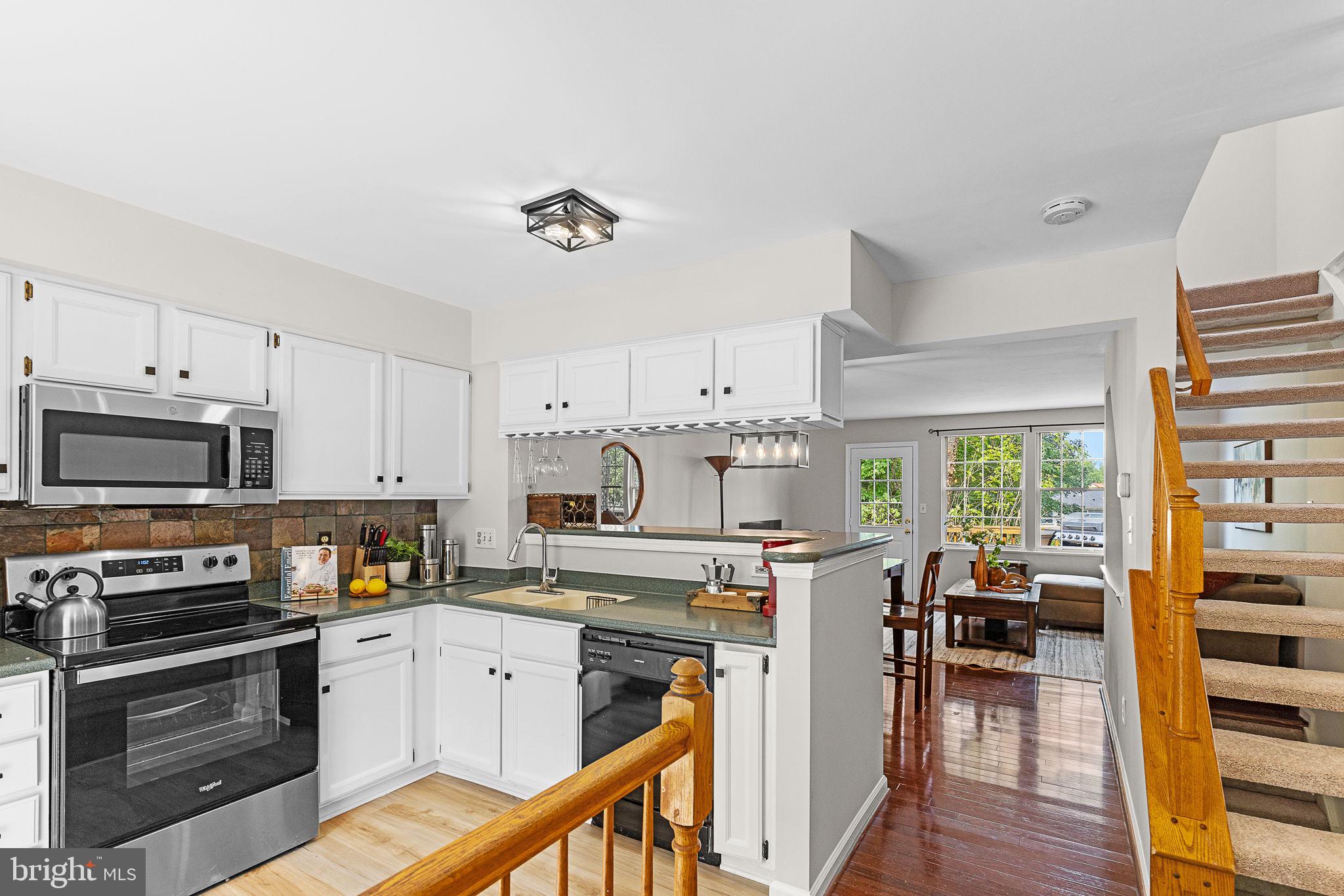 6582 Skylemar Trail Centreville, VA 20121 - Photo 13 of 46 a kitchen with stainless steel appliances a stove top oven a sink a refrigerator white cabinets and wooden floor
