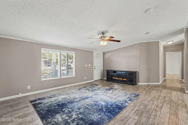 a view of a big room with wooden floor and windows