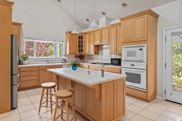 a kitchen with stainless steel appliances granite countertop a stove a sink dishwasher and cabinets with wooden floor