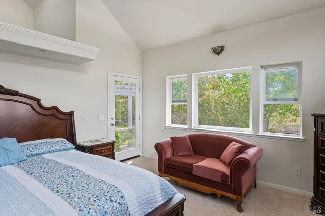 a bedroom with furniture and a large window