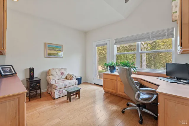 a view of a workspace with furniture and a window