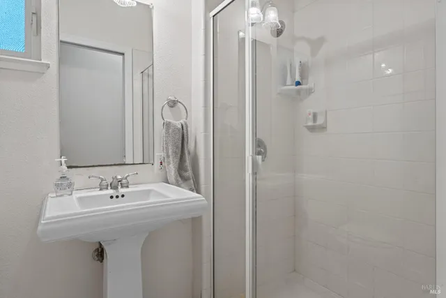 a bathroom with a sink a mirror and shower