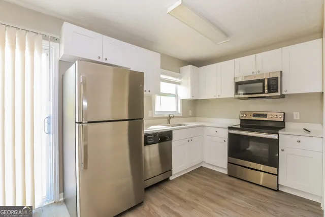 a kitchen with stainless steel appliances a refrigerator sink and microwave