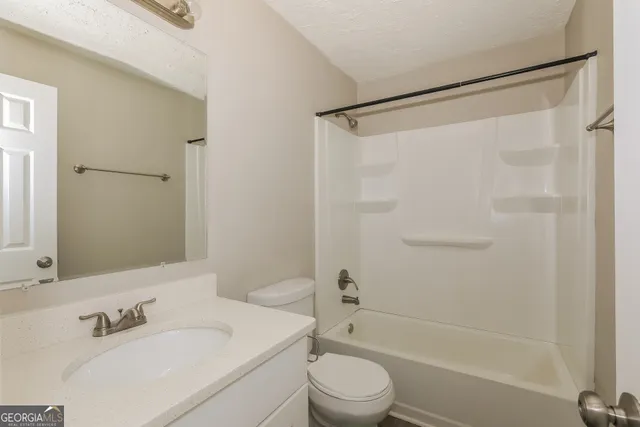 a bathroom with a bathtub shower sink vanity and toilet
