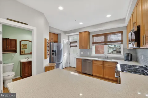a large kitchen with stainless steel appliances granite countertop a refrigerator and a stove top oven