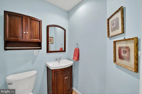 a bathroom with a toilet a sink and mirror