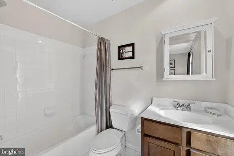 a bathroom with a granite countertop sink toilet a mirror and shower
