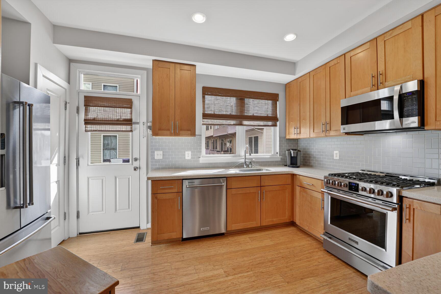 814 3rd Street Southeast Washington, DC 20003 - Photo 10 of 36 a kitchen with stainless steel appliances granite countertop a stove a sink and a microwave