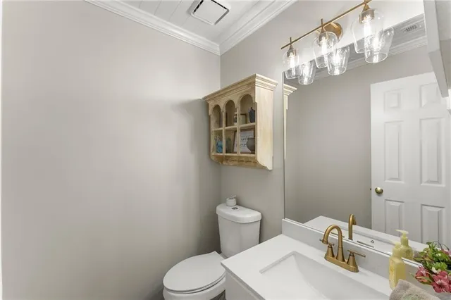 a bathroom with a sink vanity mirror and toilet