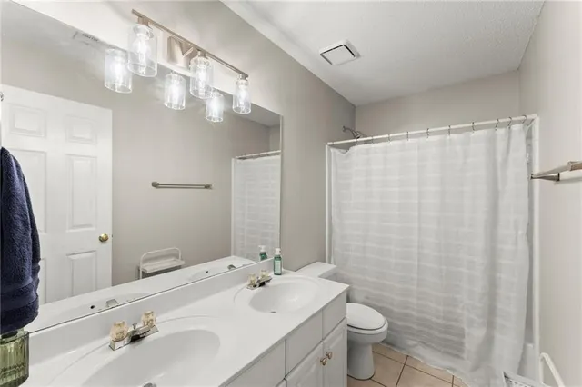 a bathroom with a sink a toilet and shower curtain