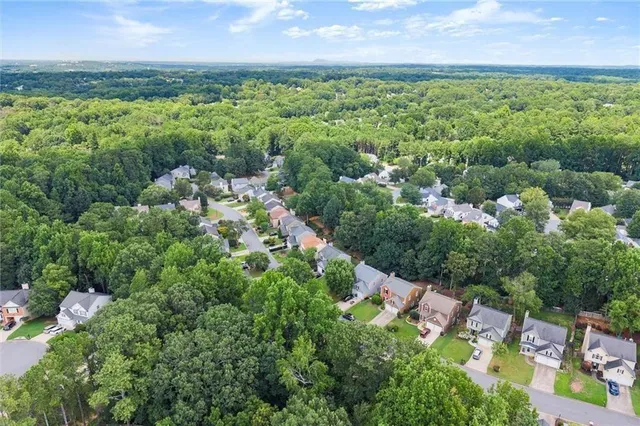 an aerial view of residential house with outdoor space and trees all around