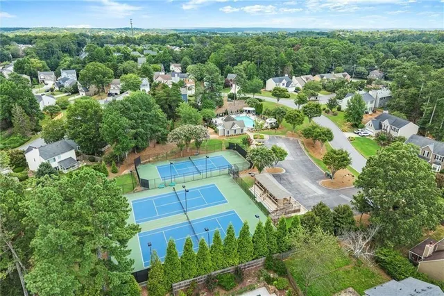 an aerial view of residential houses with outdoor space and trees