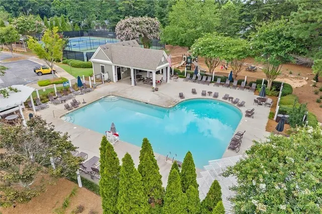 an aerial view of a house with outdoor space swimming pool patio and lake view