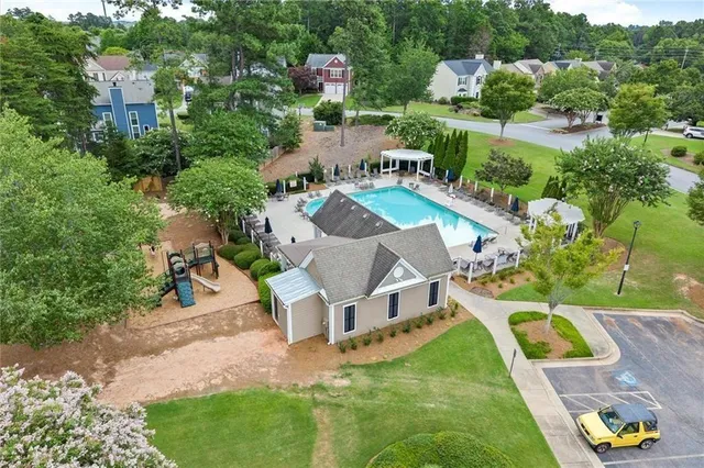 an aerial view of a house with swimming pool a yard and lake view