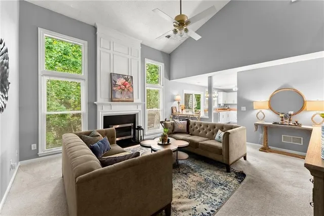 a living room with furniture a fireplace and a large window