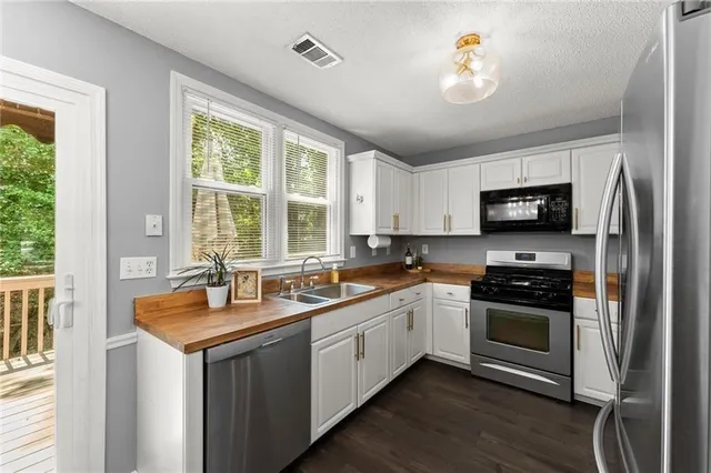 a kitchen with a stove a sink and a window