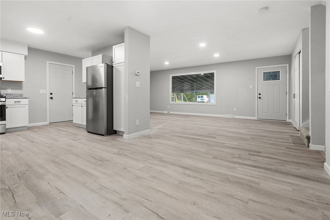 4232 Wilson Avenue Ravenna, OH 44266 - Photo 28 of 28 Kitchen featuring stainless steel appliances, open floor plan, white cabinets, recessed lighting, and light wood-style floors