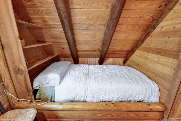 a bed sitting in a bedroom next to a window