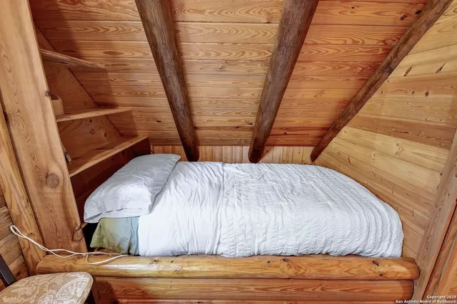 a bed sitting in a bedroom next to a window