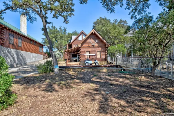 a front view of a house with a yard tree and outdoor seating