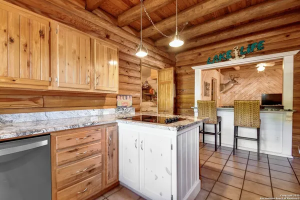 a kitchen with granite countertop a sink a stove and cabinets