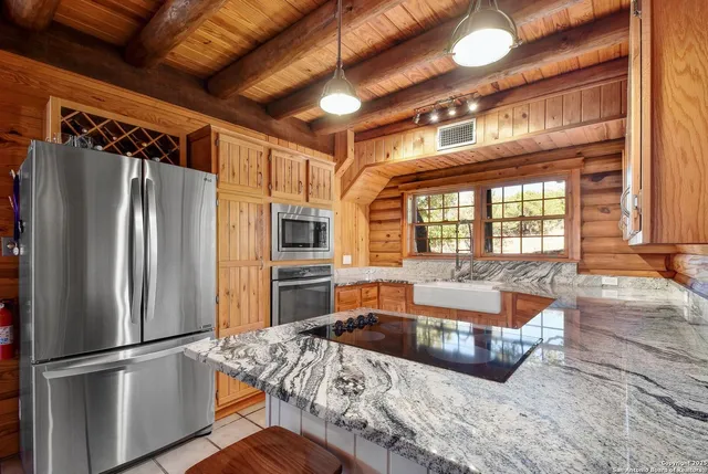a large kitchen with stainless steel appliances granite countertop a refrigerator and a sink