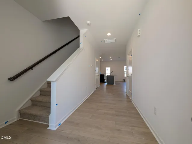 a view of a hallway with wooden floor and staircase