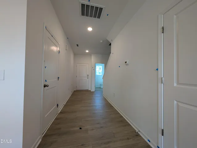 a view of a hallway with wooden floor