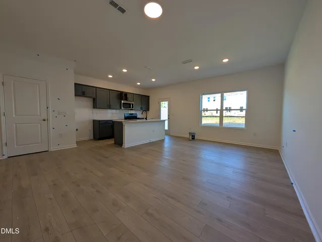 a view of empty room with wooden floor and window