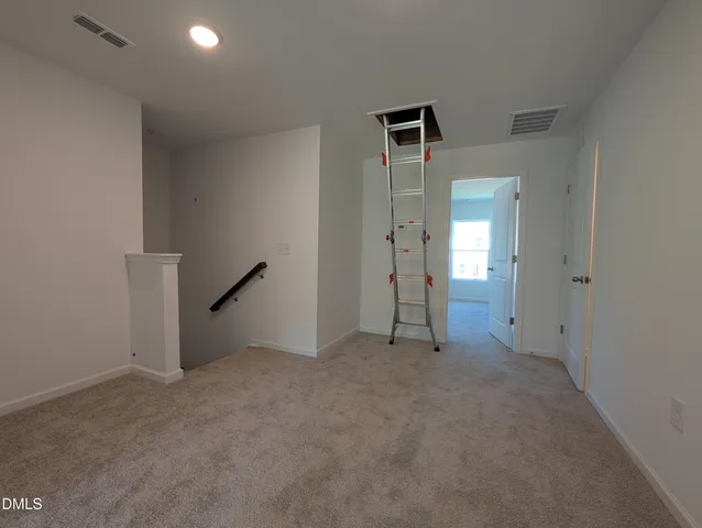 an empty room with closet and a chandelier fan