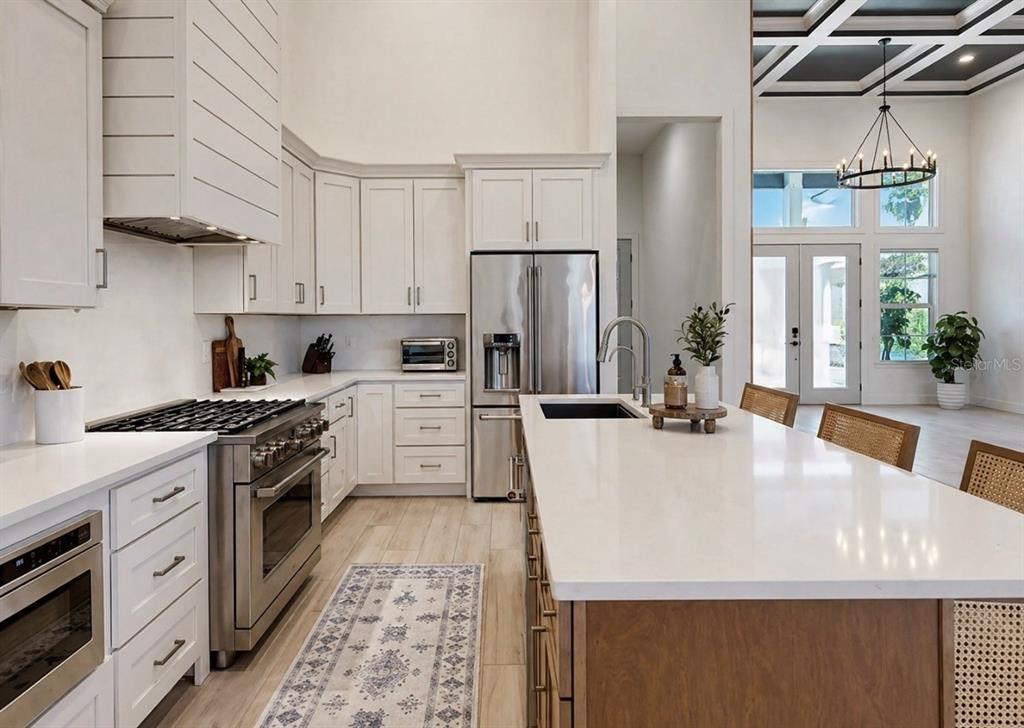 5605 Seagrass Place Apollo Beach, FL 33572 - Photo 20 of 86 a large white kitchen with stainless steel appliances granite countertop a stove a sink a refrigerator and white cabinets