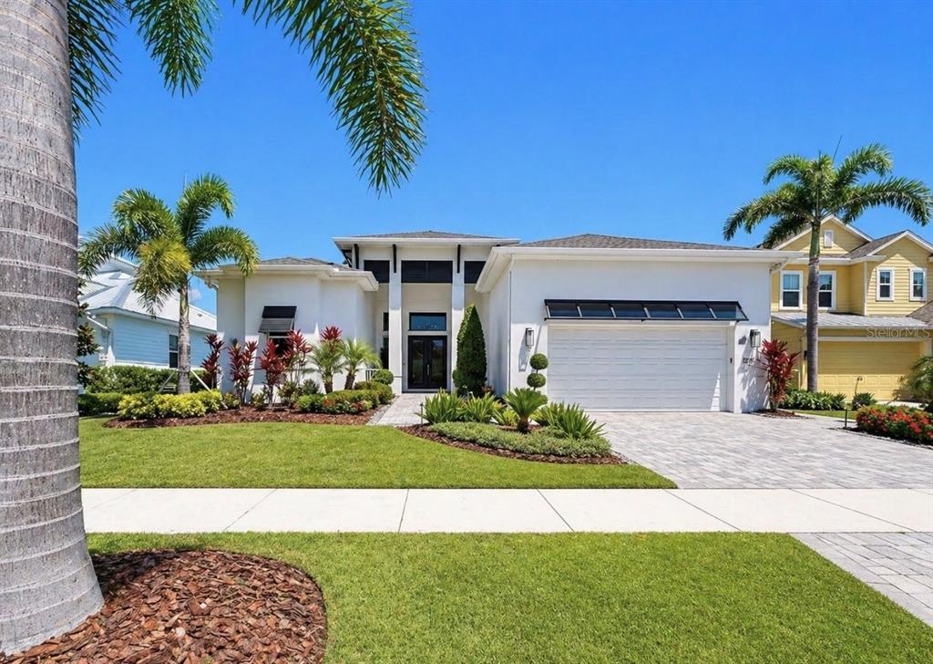 5605 Seagrass Place Apollo Beach, FL 33572 - Photo 3 of 86 a front view of a house with a garden and palm trees