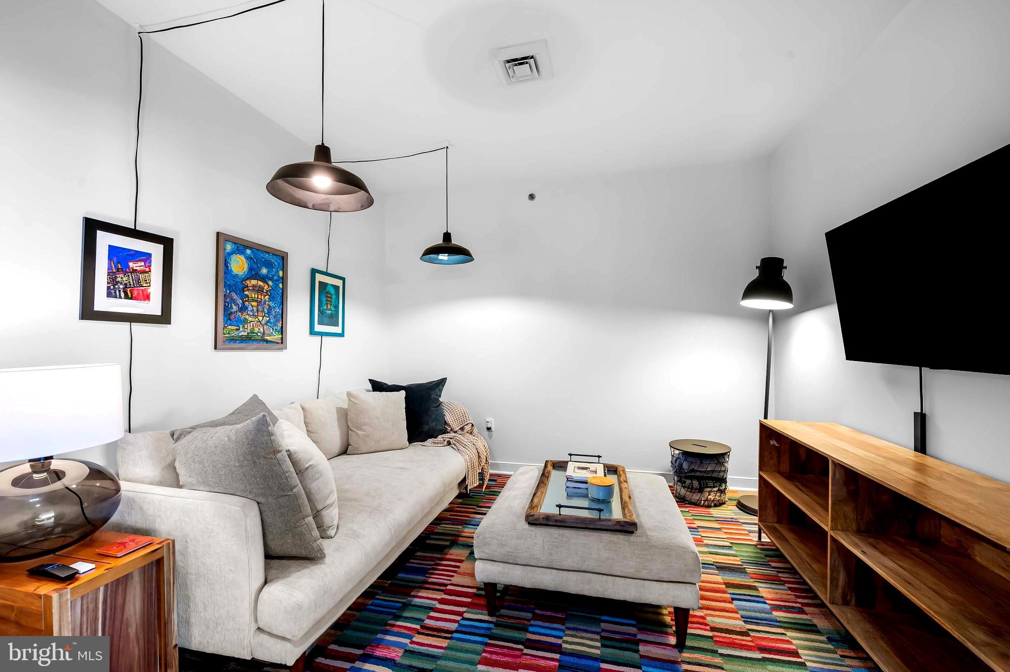 2901 Boston Street, Unit 513 Baltimore, MD 21224 - Photo 11 of 62 a living room with furniture and a flat screen tv