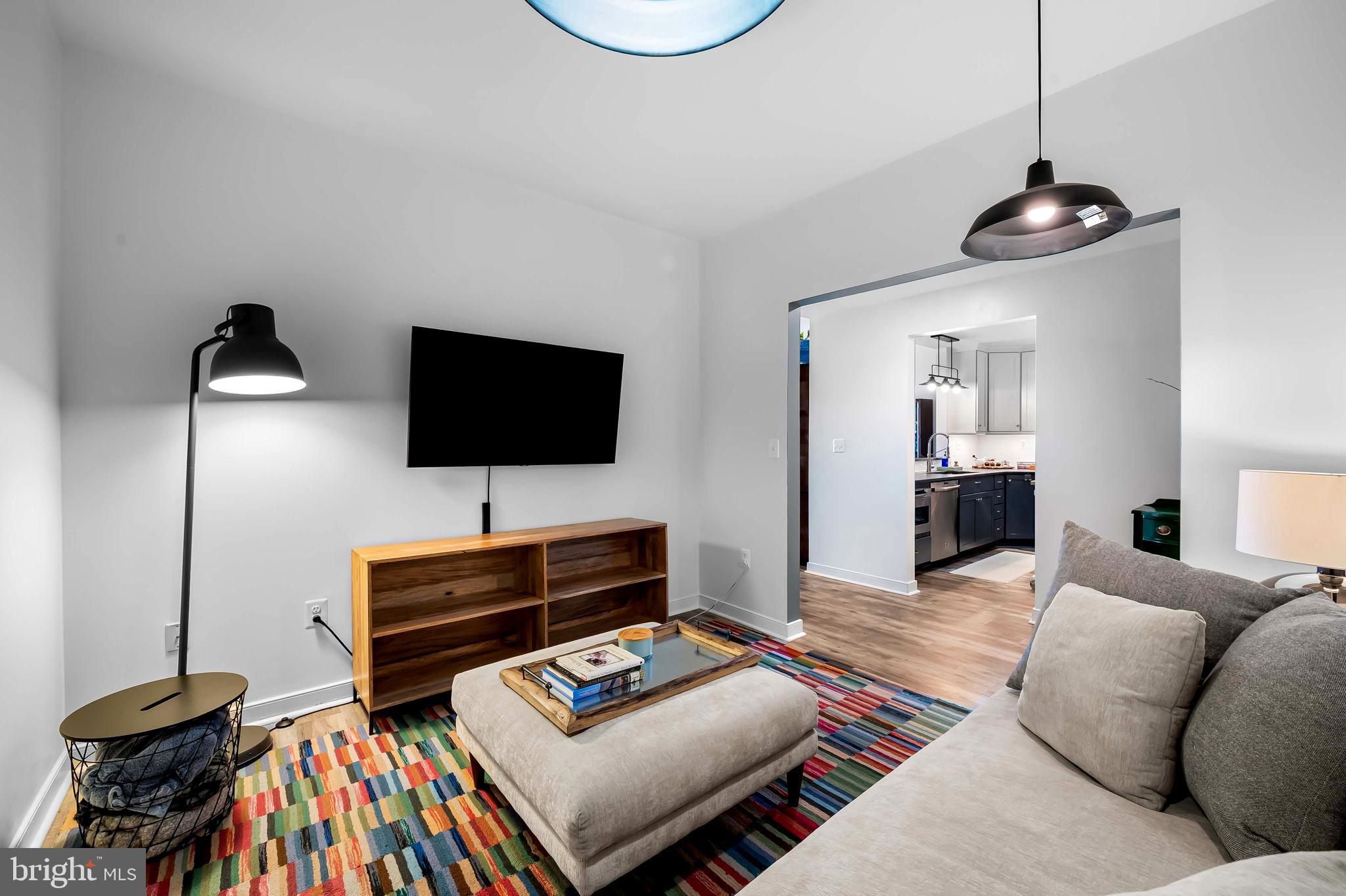 2901 Boston Street, Unit 513 Baltimore, MD 21224 - Photo 12 of 62 a living room with furniture and a flat screen tv