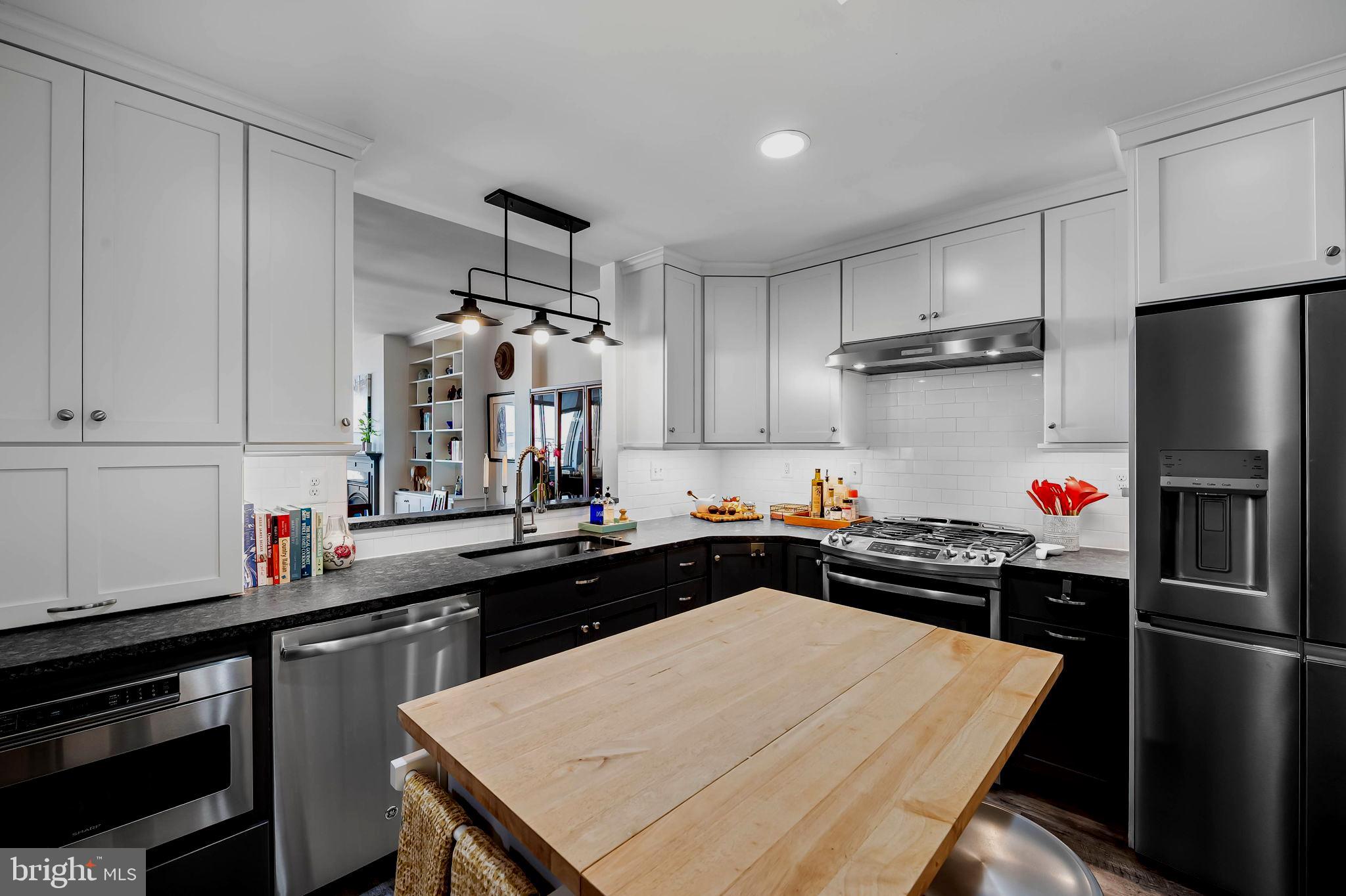 2901 Boston Street, Unit 513 Baltimore, MD 21224 - Photo 18 of 62 a kitchen with a sink refrigerator and cabinets