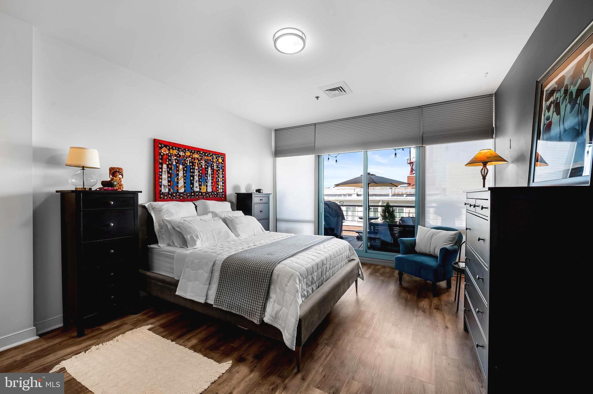 2901 Boston Street, Unit 513 Baltimore, MD 21224 - Photo 25 of 62 a bedroom with a bed and wooden floor