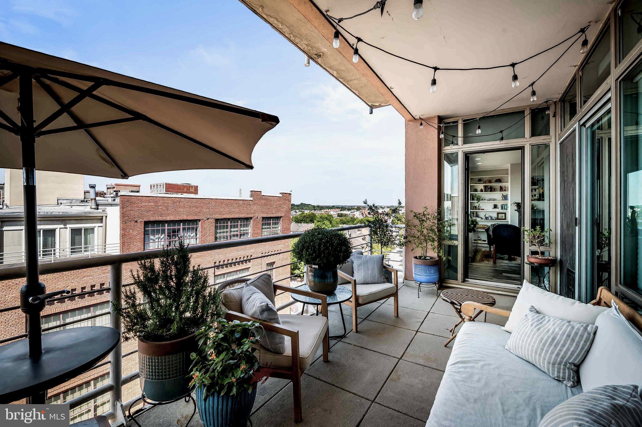 2901 Boston Street, Unit 513 Baltimore, MD 21224 - Photo 31 of 62 a view of a terrace with furniture and umbrella