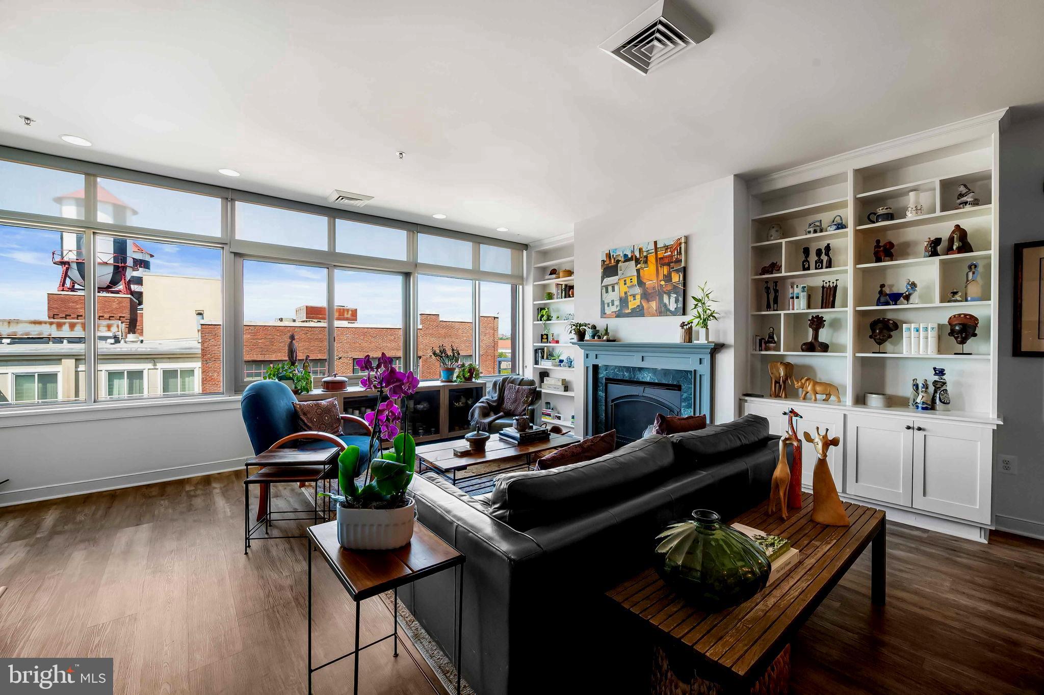 2901 Boston Street, Unit 513 Baltimore, MD 21224 - Photo 6 of 62 a living room with furniture a fireplace and a large window