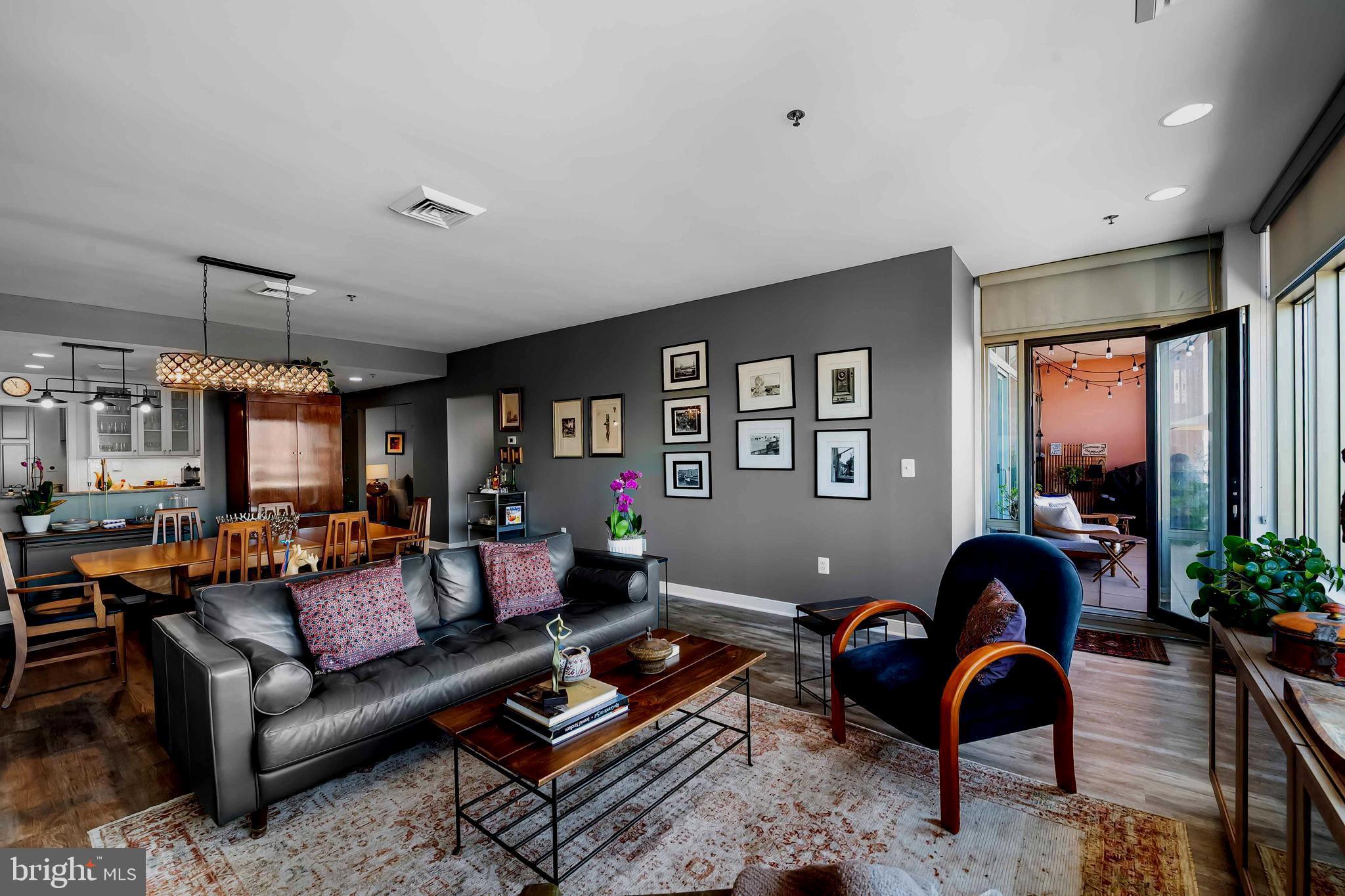 2901 Boston Street, Unit 513 Baltimore, MD 21224 - Photo 7 of 62 a living room with furniture a chandelier and a large window