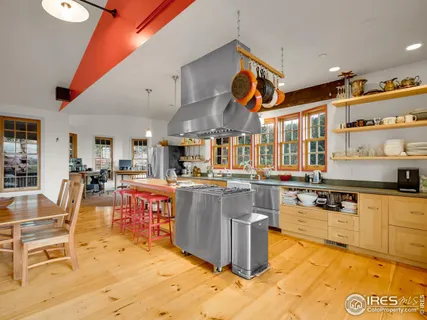 a kitchen with stainless steel appliances kitchen island granite countertop a table and chairs in it