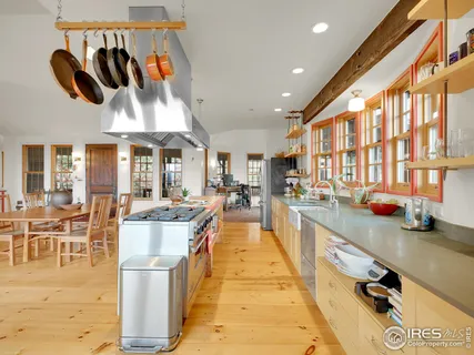 a large kitchen with stainless steel appliances kitchen island granite countertop a large counter top and a view of living room