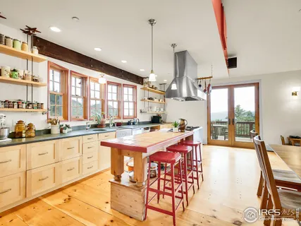 a open kitchen with stainless steel appliances granite countertop a stove and white cabinets with wooden floor