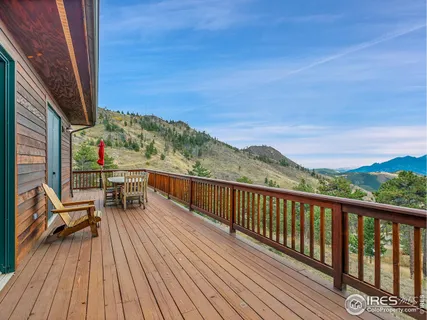 a view of a balcony with chairs and wooden floor