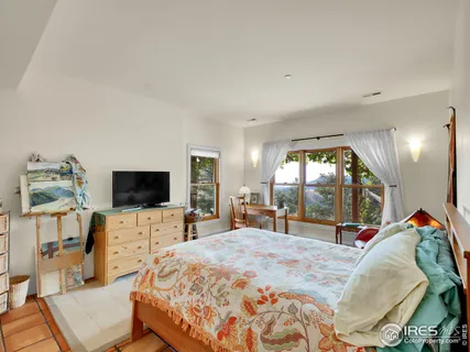 a bedroom with a bed and a flat tv screen on the dresser