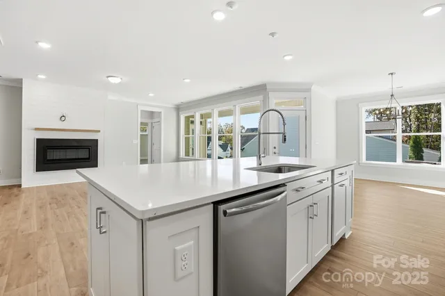 a kitchen with granite countertop a sink and a stove with wooden floor
